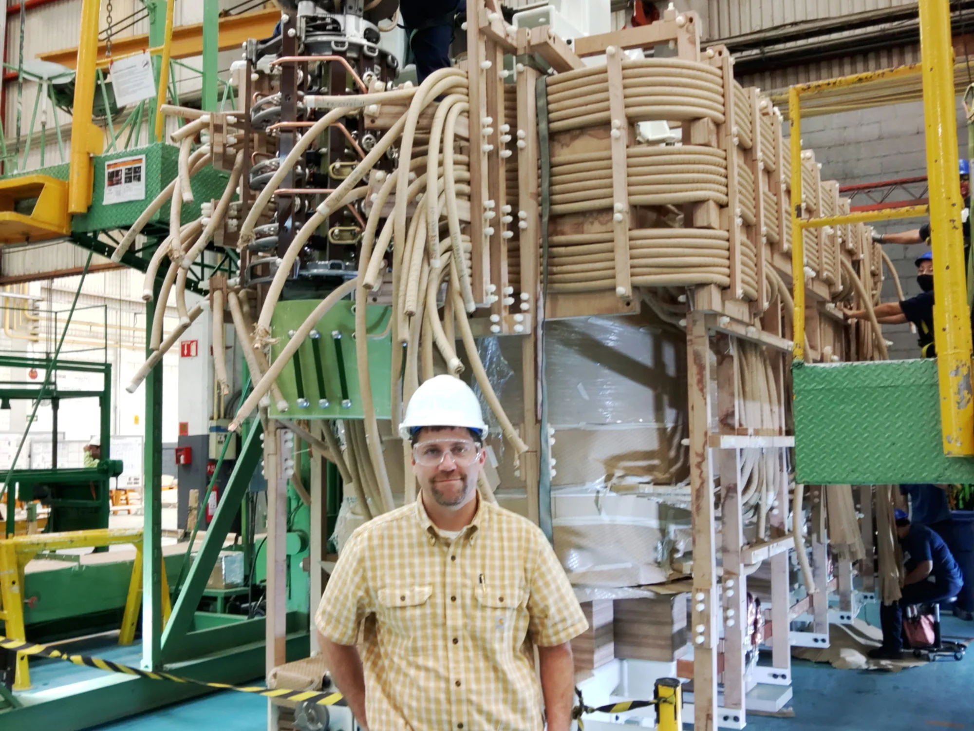 Engineer in front of a transformer assembly on a US manufacturing floor